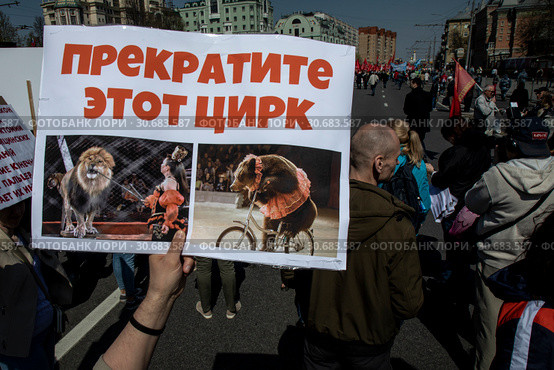 Участник Марша в защиту животных в городе Москве держит плакат с требованием запретить использование животных в цирковых номерах, Россия, 1 мая 2019. Редакционное фото, фотограф Николай Винокуров / Фотобанк Лори