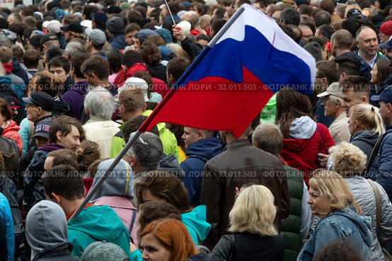Участник митинга держит российский флаг во время акции оппозиции в поддержку независимых кандидатов в депутаты Мосгордумы на проспекте Сахарова города Москвы, Россия, 10 августа 2019. Редакционное фото, фотограф Николай Винокуров / Фотобанк Лори