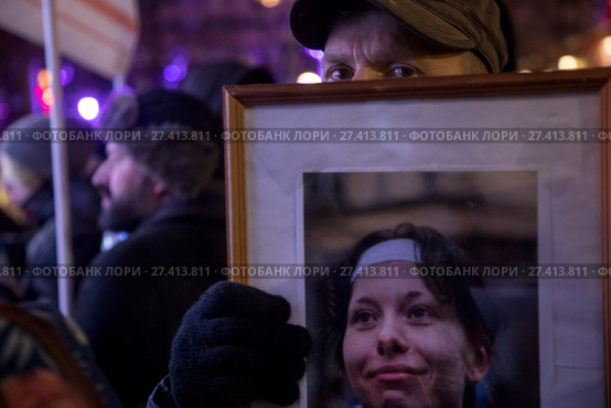 Участник шествия в память об убитых адвокате Станиславе Маркелове и журналистке "Новой газеты" Анастасии Бабуровой держит портрет Анастасии Бабуровой в центре города Москвы, Россия (2018 год). Редакционное фото, фотограф Николай Винокуров / Фотобанк Лори