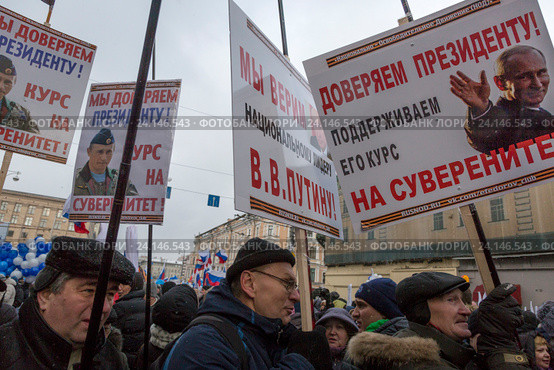 Участники шествия и митинга "Мы едины!" несут портрет президента РФ Владимира Путина в российский праздник День народного единства на Тверской улице в городе Москве, Россия 4 ноября 2016. Редакционное фото, фотограф Николай Винокуров / Фотобанк Лори