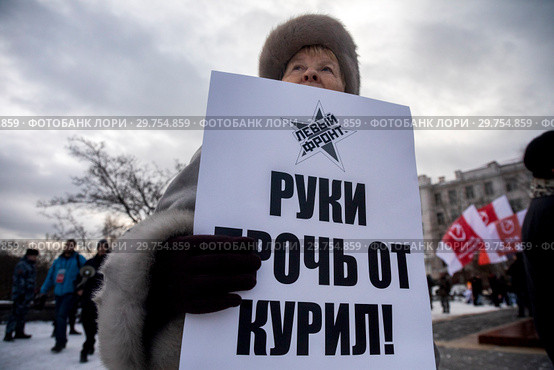 Участница акции против передачи Курильских островов Японии, организованной представителями "Левого фронта" на Суворовской площади города Москвы, держит плакат с надписью "Руки прочь от Курил" (2019 год). Редакционное фото, фотограф Николай Винокуров / Фотобанк Лори