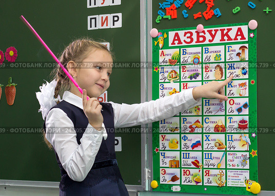 Ученица у доски составляет слова используя плакат с алфавитом (2012 год). Редакционное фото, фотограф Вячеслав Палес / Фотобанк Лори