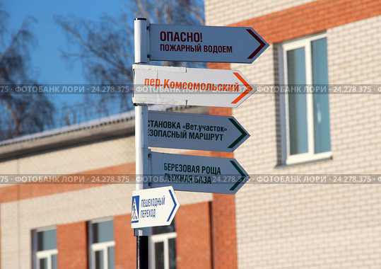 Указатели направлений движения для пешеходов на фоне школы. Стоковое фото, фотограф Марина Орлова / Фотобанк Лори