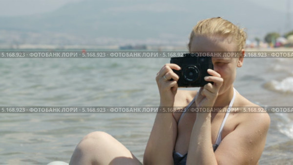 Улыбающаяся девушка на пляже снимает на фотоаппарат. Стоковое видео, видеограф Данил Руденко / Фотобанк Лори