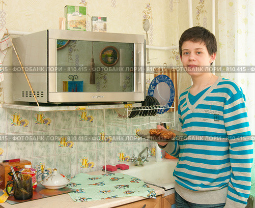 Юноша собирается разогреть еду в микроволновке (2009 год). Редакционное фото, фотограф Ирина Солошенко / Фотобанк Лори