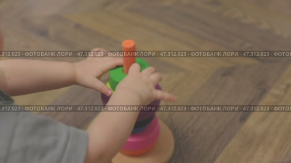 unrecognizable caucasian child baby playing toy wooden pyramid, early education. Стоковое видео, видеограф Olesia Kondrateva / Фотобанк Лори