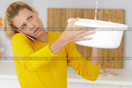 upset woman calling insurance for water leaks. Стоковое фото, агентство Ingram Publishing / Фотобанк Лори