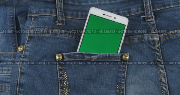 Увеличение. Смартфон с зеленым экраном торчит из кармана джинсов. Концепция. Вид сверху. Стоковое видео, видеограф Александр Собко / Фотобанк Лори