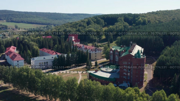 Южный Урал, бальнеологический санаторий Красноусольск летом: жилые и лечебные корпуса. Вид с воздуха. South Urals, Krasnousolsk Health Resort: territory of sanatorium, residential and medical buildings. Aerial view. (2022 год). Стоковое видео, видеограф Евгений Романов / Фотобанк Лори