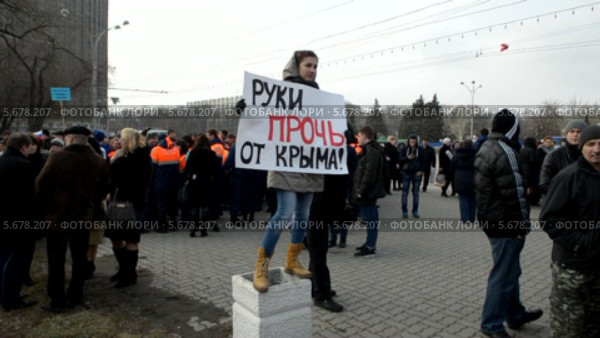 В Ростове-на-Дону состоялся митинг в поддержку русскоязычного населения Крыма. Руки прочь от Крыма! - плакат в руках девушки (2014 год). Редакционное видео, видеограф Олег Пчелов / Фотобанк Лори