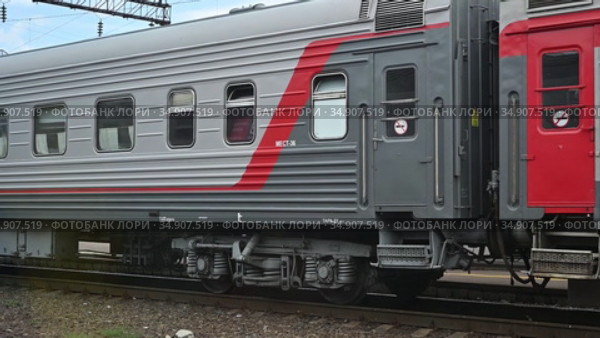 Вагоны встречного пассажирского поезда с логотипом РЖД. RZD. Oncoming passenger train Moscow-Anapa arrives on the neighboring track. (2020 год). Редакционное видео, видеограф Владимир Литвинов / Фотобанк Лори