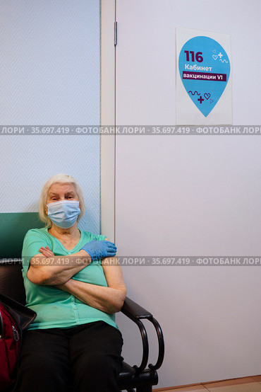 Вакцинация от COVID-19. Пожилая женщина сидит у кабинета врача после прививки Sputnik-V. Россия, Москва. Стоковое фото, фотограф ирина реброва / Фотобанк Лори