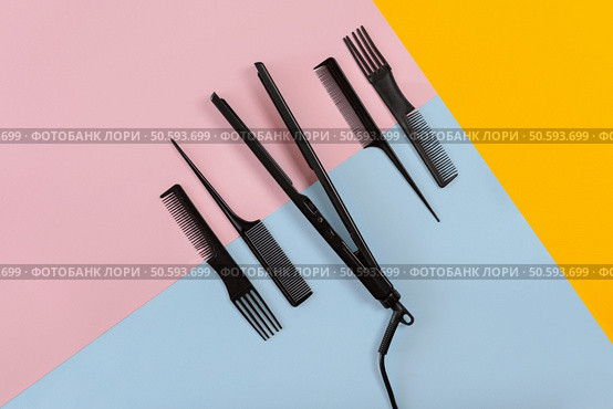 Various hair styling devices on the color blue, yellow, pink paper background, top view. Copy space. Still life. Mock-up. Flat lay. Various hair styling devices on the color blue, yellow, pink paper background, top view. Стоковое фото, агентство Ingram Publishing / Фотобанк Лори