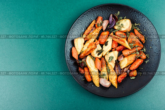 Vegan garnish of baked parsnip root, red onions, carrots and garlic. Roasted root vegetables. Space for text.. Roasted parsnip root and carrots. Стоковое фото, агентство Ingram Publishing / Фотобанк Лори