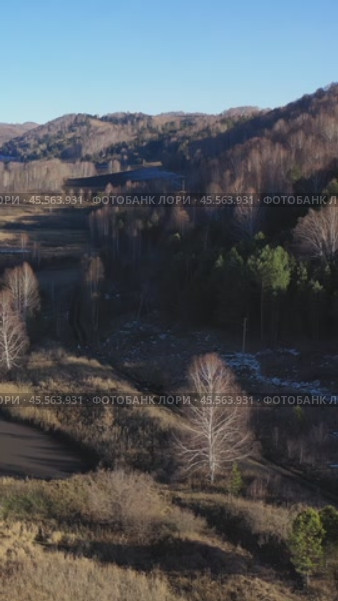Vertical drone video of flying over a hilly rural landscape with a winding road and fish ponds. Altai Krai. Стоковое видео, видеограф Сергей Пристяжнюк (Serg Zastavkin) / Фотобанк Лори