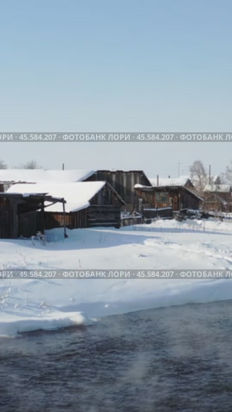 Vertical video of russian Altai country village Semiletka and river Koksha in winter season. The banks are covered with snow. Стоковое видео, видеограф Сергей Пристяжнюк (Serg Zastavkin) / Фотобанк Лори