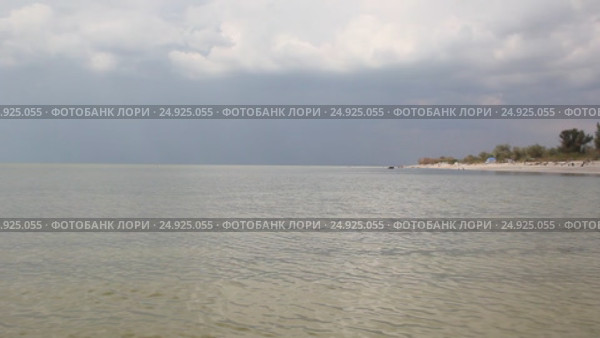 Вид на песчаную косу со стороны моря. Грозовые облака затягивают небо. Стоковое видео, видеограф Олег Хархан / Фотобанк Лори