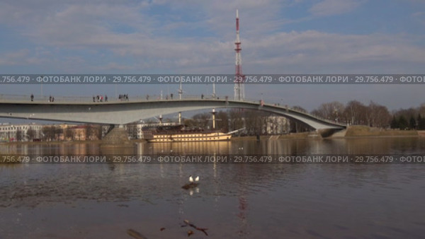 Вид на пешеходный мост и реку Волхов апрельским днем. Великий Новгород, Россия (2018 год). Стоковое видео, видеограф Виктор Карасев / Фотобанк Лори