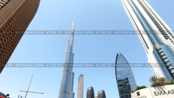View of Burj Khalifa at blue sky and urban street with cars of Dubai city, UAE (2023 год). Редакционное видео, видеограф Aleksandr Golubev / Фотобанк Лори