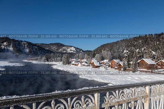 View of the winter Altai with the Biya river, Artybash village, mountains on the horizon and the lattice of the bridge covered with hoarfrost. Altai Republic, Russia (2020 год). Стоковое фото, фотограф Наталья Волкова / Фотобанк Лори