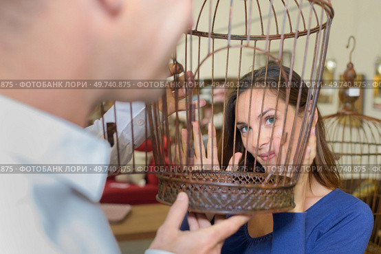 View of woman's face through birdcage. Стоковое фото, агентство Ingram Publishing / Фотобанк Лори
