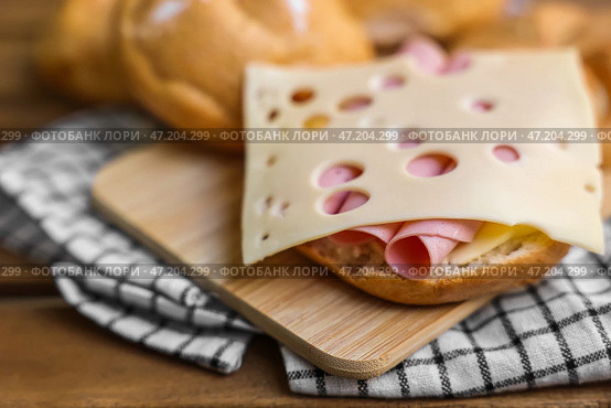 Вкусные роллы кайзер с ветчиной и сыром на деревянной доске. Стоковое фото, фотограф Pixel_shot / Фотобанк Лори