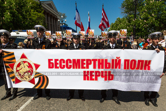 Военнослужащие держат баннер с надписью "Бессмертный полк Керчь" во время акции-шествия на центральной улице города Керчи в День Победы 9 мая, Республика Крым (2016 год). Редакционное фото, фотограф Николай Винокуров / Фотобанк Лори