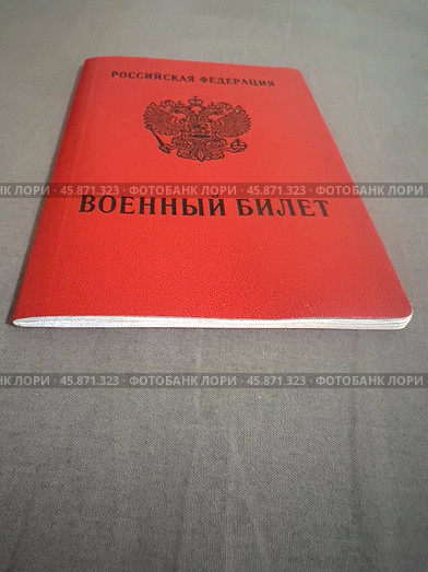 Военный билет на серой ткани. Стоковое фото, фотограф Ярославский Максим / Фотобанк Лори