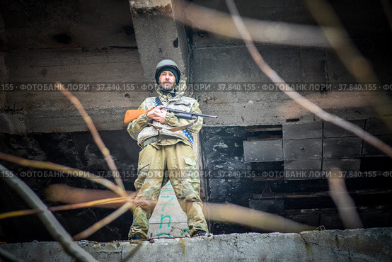 Вооружённый солдат в городских развалинах. Наёмник в промзоне. (2021 год). Редакционное фото, фотограф Виталий Михайлюк / Фотобанк Лори