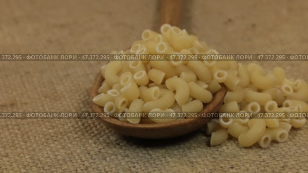 Вращающаяся ложка, наполненная макаронами, лежащими на мешковине. Крупный план. Стоковое видео, видеограф Александр Собко / Фотобанк Лори