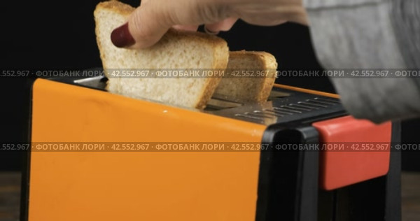 Выпекайте хлеб в тостере, чтобы приготовить бутерброды на завтрак. Вставьте тосты и включите тостер. Making bread in a toaster, sandwiches for breakfast. Стоковое видео, видеограф Александр Собко / Фотобанк Лори