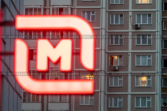 Вывеска на продуктовом магазине с эмблемой торговой сети "Магнит" на фоне жилых домов в городе, Россия (2020 год). Редакционное фото, фотограф Николай Винокуров / Фотобанк Лори