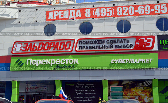 Вывески "Аренда", "Эльдорадо" и "Перекресток" на фасаде здания торгового центра в городе Королёв (Московская область) (2015 год). Редакционное фото, фотограф Александр Замараев / Фотобанк Лори