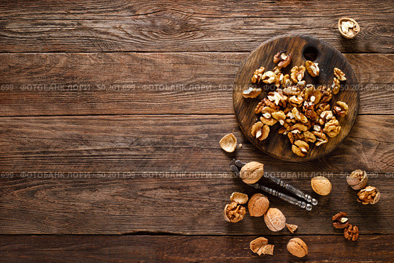 Walnuts. Kernels and whole nuts on wooden rustic table, top view. Стоковое фото, агентство Ingram Publishing / Фотобанк Лори