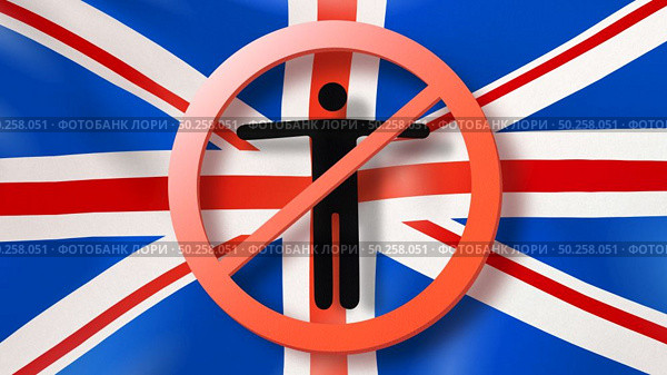 Warning sign with crossed out man on the background of British flag. Restriction of entry into Great Britain. Coronavirus, Covid 19 pandemic, Quarantine concept.. Prohibition sign with crossed out man on a background British flag. Стоковое фото, агентство Ingram Publishing / Фотобанк Лори