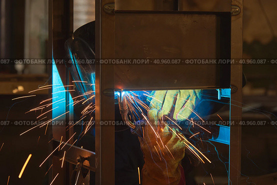 Welder welds metal parts, lots of smoke and sparks, harmfulness, worker. Стоковое фото, фотограф Стас Пересыпкин / Фотобанк Лори