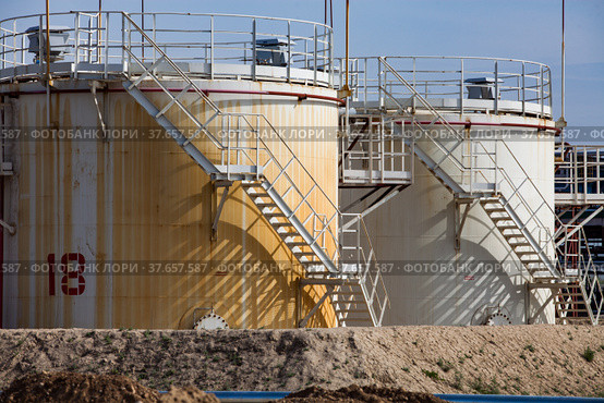 White and yellow oil storage tanks on bright sun on blue sky. Close up. Oil refinery plant in desert. Near Taraz city. Стоковое фото, фотограф Alexey Rezvykh / Фотобанк Лори