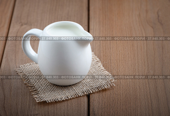 White jug with milk on a wooden rustic background. Стоковое фото, фотограф Наталия Попова / Фотобанк Лори