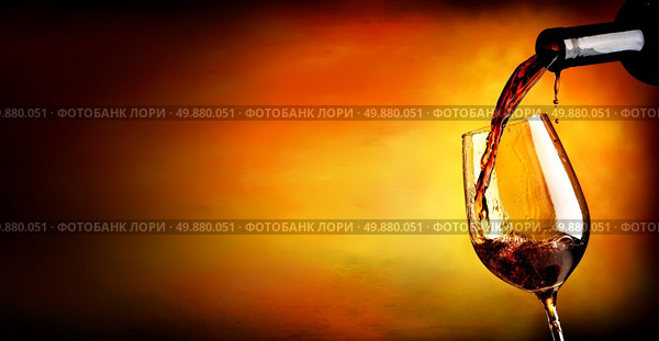Wine pouring in wineglass  on an orange background. Стоковое фото, агентство Ingram Publishing / Фотобанк Лори