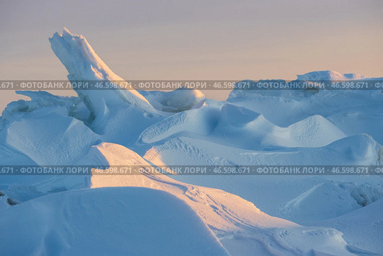 Winter arctic landscape. View of snow and ice at sunset. Ice hummocks on the frozen sea in the Arctic. Cold frosty winter weather. Harsh polar climate. Travel and hikes to the far north to the Arctic. Стоковое фото, фотограф Андрей Степанов / Фотобанк Лори