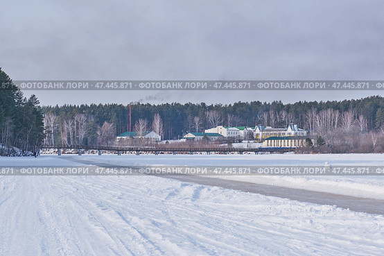 Winter ice path for skating and view of bridge, Sysert pond, Ural, Russia. Стоковое фото, фотограф Ирина Кононова / Фотобанк Лори