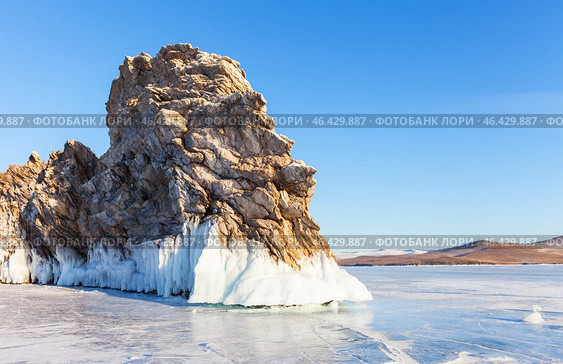 Winter landscape of frozen Baikal Lake. View of Dragon Cape on edge of Ogoy Island - natural landmark against background of blue sky in sunny cold day. Nature background. Winter travels and outdoors. Стоковое фото, фотограф Виктория Катьянова / Фотобанк Лори