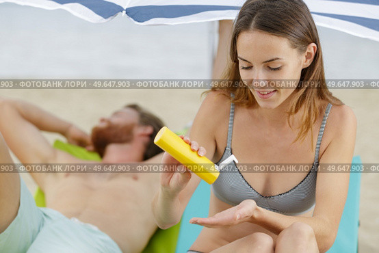 woman applying suncream on the beach. Стоковое фото, агентство Ingram Publishing / Фотобанк Лори