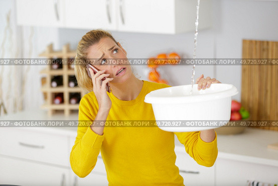 woman calling to plumber for water leakage problem. Стоковое фото, агентство Ingram Publishing / Фотобанк Лори