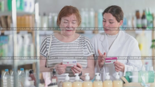 Woman choosing paracetamol with help from pharmacist. Стоковое видео, видеограф Яков Филимонов / Фотобанк Лори