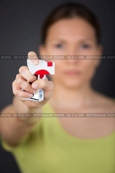 woman crushing cigarette packet in outstretched hand. Стоковое фото, агентство Ingram Publishing / Фотобанк Лори