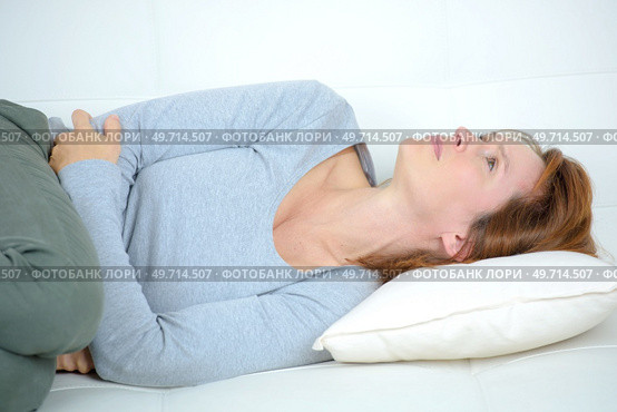 woman curled up on sofa. Стоковое фото, агентство Ingram Publishing / Фотобанк Лори