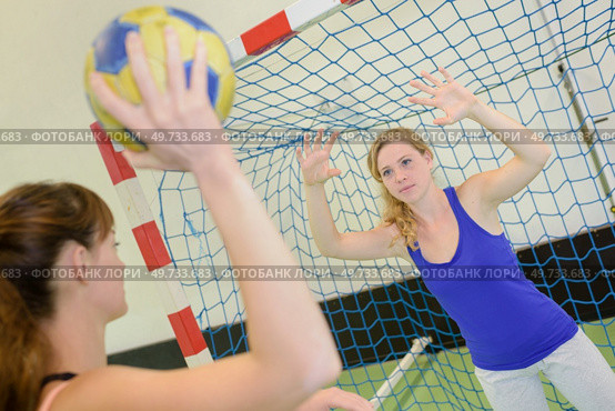 Woman defending handball net from opponent. Стоковое фото, агентство Ingram Publishing / Фотобанк Лори