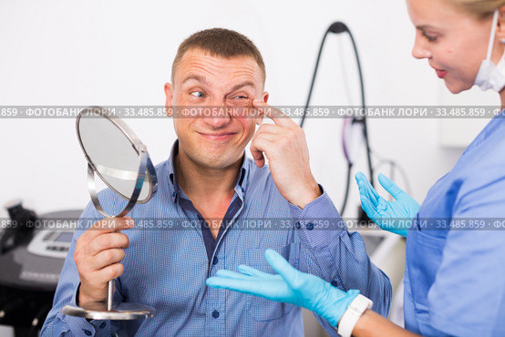 Woman doctor is examining patient behind mirror before the procedure. Стоковое фото, фотограф Яков Филимонов / Фотобанк Лори