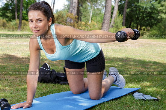 woman doing various exercises with dumbbell and mat. Стоковое фото, агентство Ingram Publishing / Фотобанк Лори